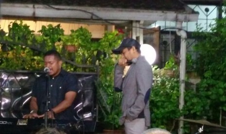 Penyanyi Glenn Fredly melakukan pemanasan sebelum bernyanyi di malam ibadah penghiburan di rumah duka Mike Mohede.