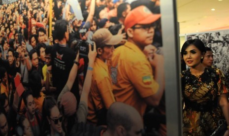 Penyanyi Yuni Shara mengamati pameran foto bertajuk Musik Untuk Demokrasi di Main Atrium East Mall Grand Indonesia, Jakarta, Selasa (14/10).