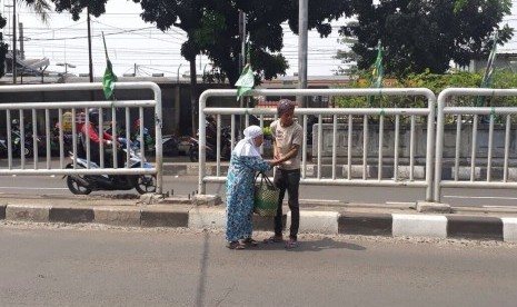 Penyeberang jalan memilih jalan pintas menerobos pagar karena tidak ada fasilitas jembatan penyeberangan orang (JPO) di Pasar Minggu, Jumat (21/7).