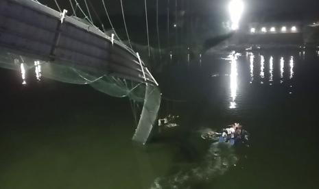  Penyelamat di atas kapal mencari korban jembatan jatuh di Sungai Machu di kawasan Morbi, Gujarat Barat, India, Ahad (30/10/2022). 