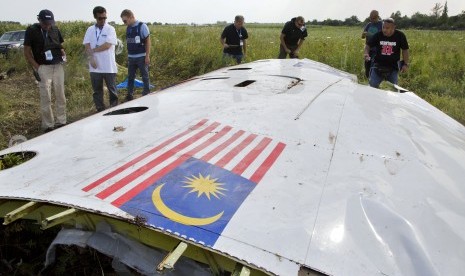 Penyelidik Malaysia sedang memerika puing pesawat Malaysia Airlines MH17 yang jatuh di wilayah Ukraina