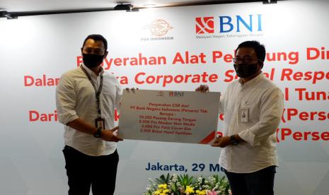 Penyerahan APD secara simbolis oleh Direktur Hubungan Kelembagaan BNI Sis Apik Wijayanto kepada Direktur Hubungan Strategis dan Kelembagaan PT Pos Noer Fajrieansyah di Jakarta, Jumat (29/5). 