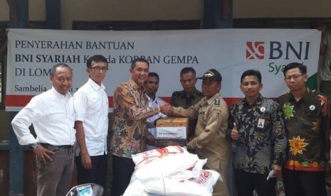 Penyerahan Bantuan BNI Syariah kepada Korban Gempa di Desa Obel – Obel, Sambelia, Lombok Timur, NTB (kiri – kanan) Pemimpin Wilayah Timur, Imam Hidayat Sunarto; Pemimpin Divisi Layanan dan Jaringan, Adjat Djatnika; SEVP Bisnis Retail dan Jaringan, Iwan Abdi menyerahkan bantuan kepada Camat Simbelia, Drs. Zaitul Akmal MM ditemani oleh Pemimpin Cabang BNI Syariah Cakranegara Mataram, Agus Nugroho; dan Pemimpin Cabang BNI Syariah Mataram, Mansyur (30/7).