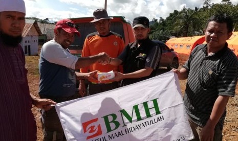 Penyerahan bantuan relawan BMH-SAR Hidayatullah dan Pos Dai ke Desa Tapuwatu, Konawe Utara,  diterima langsung Kepala Desa Tapuwatu, Ahmad (kedua dari kanan), Kamis (13/6).