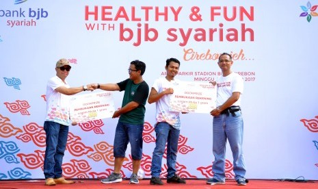 Penyerahan Hadiah Doorprize oleh Direktur Dana Jasa Toto Susanto dan Pemimpin Divisi Dana dan Jasa Asep Ghofir pada pelaksanaan Healthy and Fun with bank bjb syariah di Stadion Bima, Cirebon. Foto: Istimewa