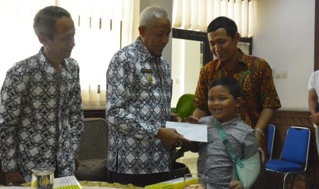 Penyerahan santunan yang diberikan Bupati Sleman, Sri Purnomo, kepada korban-korban pohon tumbang di Kabupaten Sleman.