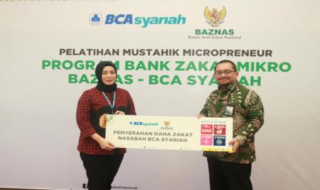 Penyerahan Zakat - Sekretaris Perusahaan PT Bank BCA Syariah Nadia Amalia Sekarsari berphoto bersama Plt. Direktur Pendayagunaan dan Layanan UPZ dan CSR BAZNAS saat seremoni penyerahan dana zakat nasabah BCA Syariah kepada BAZNAS di Kantor Kecamatan Pulo Gadung, Jakarta (13/9). Dana zakat nasabah BCA Syariah akan disalurkan melalui program Bank Zakat Mikro kepada para mustahik dalam bentuk pendanaan, pelatihan dan pendampingan usaha mikro oleh BAZNAS