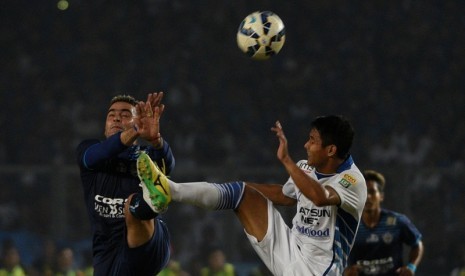 Penyerang Arema Cronus Cristian Gonzales (kiri) berduel dengan pemain Persib Purwaka Yudi.