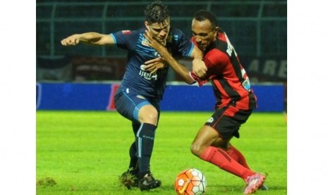 Penyerang Arema Cronus Gustavo Giron (kiri) berdue bola dengan bek Persipura Rony Beroperay