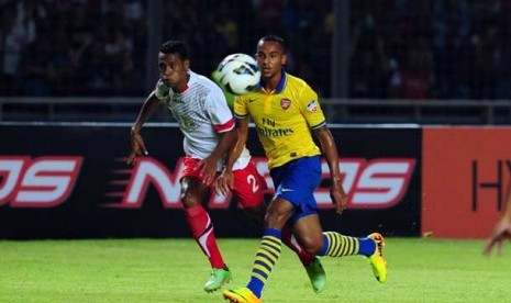 Penyerang Arsenal Theo Walcott (kuning) berebut bola dengan pemain Timnas Indonesia dalam laga persahabatan di Gelora Bung Karno, Senayan, Jakarta, Ahad (14/7) malam. 