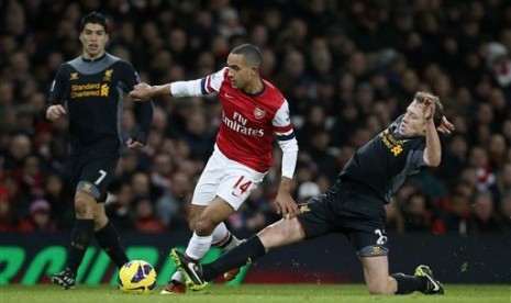 Penyerang Arsenal Theo Walcott (tengah) berebut bola dengan gelandang Liverpool Lucas Leiva pada lanjutan Liga Primer Inggris di Emirates Stadium, Kamis (31/1) dini hari. Laga itu berakhir 2-2.