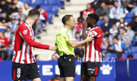 Penyerang Athletic Club Bilbao Inaki Williams (kanan) berbincang dengan wasit Del Cerro Grande (tengah) selama pertandingan LaLiga mereka di Stadion RCDE di Cornella de Llobregat, Barcelona, ??Spanyol, 16 Februari 2025.