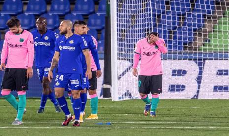 Penyerang Barcelona Lionel Messi (kanan) tertunduk saat melawan Getafe dalam lanjutan La LIga, Ahad (18/10) dini hari WIB. Barcelona takluk 0-1 dari Getafe.