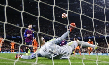 Penyerang Barcelona Lionel Messi mencetak gol saat penalti di babak pertama leg kedua di 16 besar Liga Champions antara FC Barcelona dan Olympique Lyon di stadion Camp Nou, Barcelona, Spanyol, Rabu (13/3). 