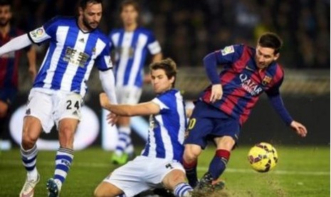 Penyerang Barcelona Lionel Messi saat berusaha melewati pertahanan Real Sociedad, Senin (5/1) dini hari WIB.