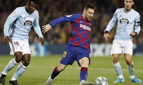 Penyerang Barcelona Lionel Messi (tengah) dijaga dua pemain Celta Vigo.