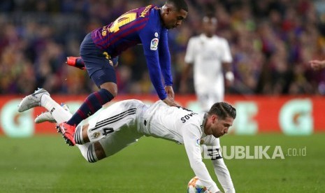 Penyerang Barcelona Malcom berduel dengan bek Real Madrid Sergio Ramos pada leg pertama semifinal Copa del Rey di stadion Camp Nou di Barcelona, Spanyol, Rabu (6/2/2019). 