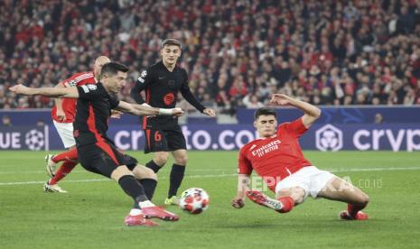 Penyerang Barcelona Robert Lewandowski berusaha mencetak gol ke gawang Benfica dalam pertandingan Liga Champions.