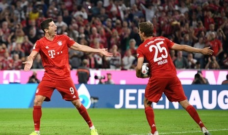 Penyerang Bayern Muenchen Robert Lewandowski (kiri) merayakan golnya ke gawang Hertha Berlin.