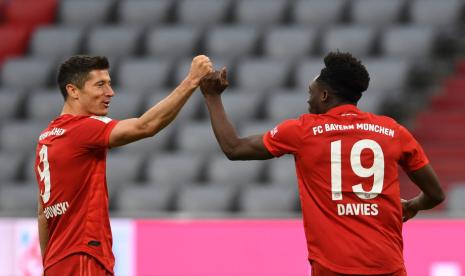 Penyerang Bayern Munchen Robert Lewandowski (kiri) dan Alphonso Davies merayakan gol ke gawang Fortuna Dusseldorf.