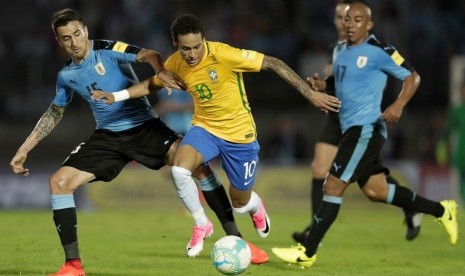 Penyerang Brasil Neymar (kanan) saat menghadapi Uruguay.