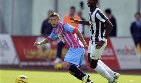 Penyerang Catania, Alejandro Gomez, terlihat berebut bola dengan gelandang Juventus, Paul Pogba, pada partai yang berlangsung di Stadio Angelo Massimino, Catania, Ahad (28/10) malam.