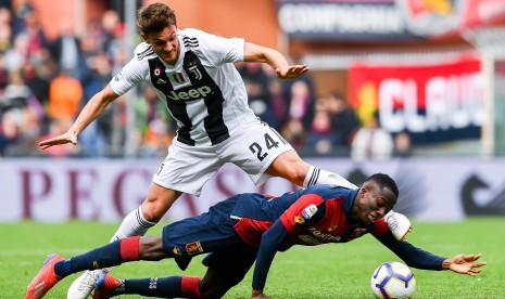 Penyerang Genoa Christian Kouame (bawan) saat berebut bola dengan bek Juventus Daniele Rugani.