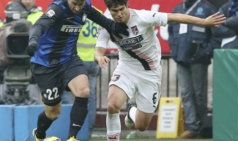 Penyerang Inter Milan, Diego Milito, berebut bola dengan bek Palermo, Ezequiel Munoz, di Guiseppe Meazza, Ahad (3/12) malam. Inter menang 1-0 pada pertandingan tersebut.