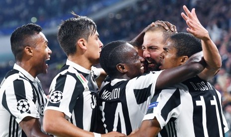 Penyerang Juventus Gonzalo Higuain dipeluk oleh rekan setimnya setelah melesakkan gol pembuka pada laga Liga Champions Grup B antara Juventus dan Olympiakos SFP di Stadion Allianz, Turin, Italia, Kamis (28/9) dini hari WIB. Juve menang 2-0. 