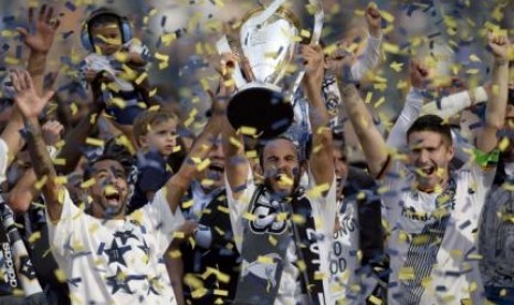 Penyerang LA Galaxy Landon Donovan mengangkat trofi juara MLS 2015 setelah di final mengalahkan New England Revolution 2-1, Senin (8/12) WIB.