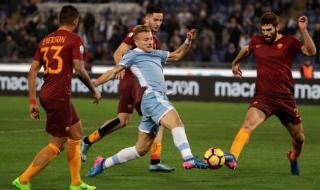 Penyerang Lazio Ciro Immobile (tengah) berusaha melewati para pemain AS Roma.