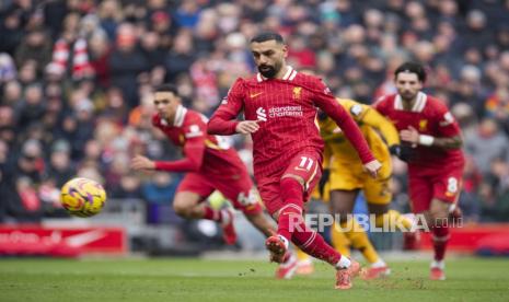 Penyerang Liverpool Mohamed Salah mencetak gol dari titik penalti ke gawang Wolverhampton Wanderers dalam pertandingan Liga Primer Inggris di Anfield, Ahad (16/2/2025).