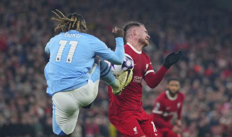 Penyerang Manchester City Jeremy Doku (kiri) menendang bola sekaligus dada pemain Liverpool Alexis Mac Allister dalam pertandingan Liga Primer Inggris di Anfield.