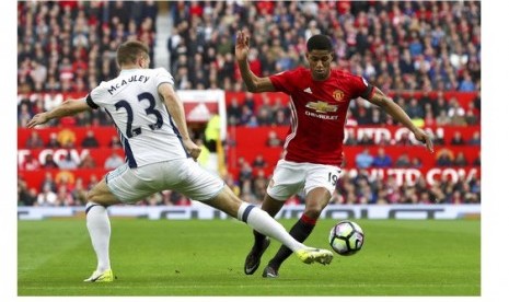 Penyerang Manchester United Marcus Rashford (kanan) berusaha melewati pemain West Bromwich Albion Gareth McAuley dalam pertandingan Liga Primer Inggris di Old Trafford, Sabtu (1/4).