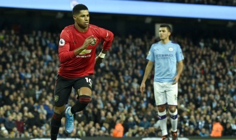 Penyerang Manchester United (MU) Marcus Rashford merayakan golnya ke gawang Manchester City. MU mengalahkan City 2-1 pada laga derby Manchester, Ahad (8/12) dini hari WIB..