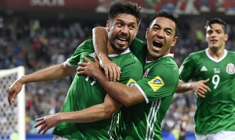 Penyerang Meksiko Oribe Peralta (kiri) merayakan golnya ke gawang Selandia Baru bersama rekannya Marco Fabian pada laga Piala Konfederasi, Kamis (22/6) dini hari WIB.