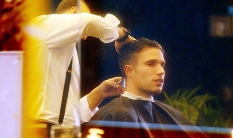 Penyerang MU, Robin Van Persie sedang memangkas rambut