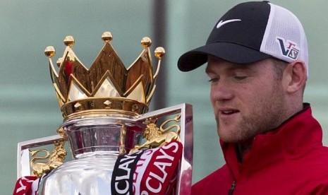 Penyerang MU, Wayne Rooney memegang trofi Liga Primer Inggris, sesaat sebelum parade kemenangan di Manchester, Inggris, Senin (13/5/2013)