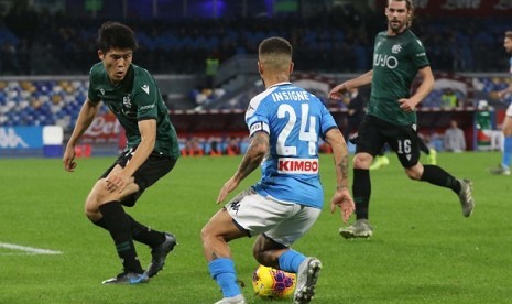 Penyerang Napoli Lorenzo Insigne mencoba melewati pemain Bologna Takehiro Tomiyasu dalam pertandingan di Stadion San Paolo, Senin (2/12) dini hari WIB.