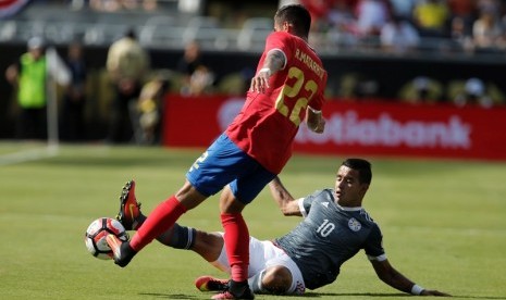 Penyerang Paraguay Derlis Gonzalez (kanan) dan bek Kosta Rika Ronald Matarrita berebut bola. 