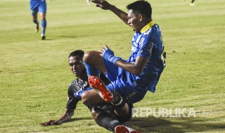 Penyerang Persib Bandung Frets Listianto Butuan (kanan) terjatuh saat pertandingan Sepak Bola Liga 1 2019 di Stadion Si Jalak Harupat, Kabupaten Bandung, Selasa (18/6). 