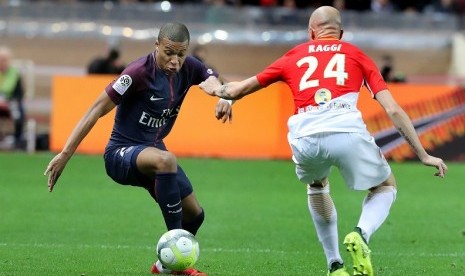 Penyerang PSG Kylian Mbappe (kiri) saat hendak melewati pemain AS Monaco.