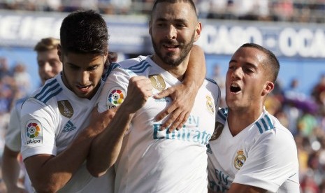 Penyerang Real Madrid asal Prancis Karim Benzema (tengah) merayakan golnya ke gawang Getafe bersama rekan setimnya, Marco Asensio (kiri) dan Lucas Vazquez pada lanjutan La Liga Spanyol di Stadion Coliseum Alfonso Perez, Sabtu (14/10) waktu setempat. 