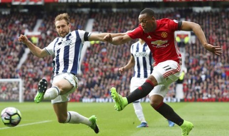 Penyerang sayap Manchester United Anthony Martial (kanan) berusaha melepaskan tendangan meski dijaga oleh pemain West Bromwich Albion.