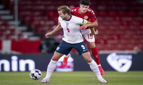 Penyerang tim nasional Inggris Harry Kane (bawah) dijaga pemain Denmark Christian Noergaard dalam laga UEFA Nations League. 