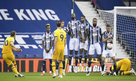 Penyerang Tottenham Harry Kane (kiri) melakukan tendangan bebas pada pertandingan sepak bola Liga Premier Inggris antara West Bromwich Albion dan Tottenham Hotspur di West Bromwich, Inggris, Ahad (8/11).