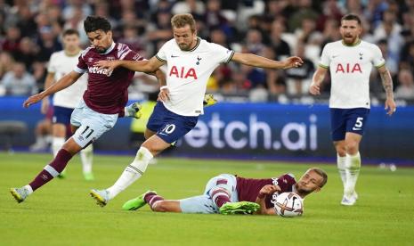   Penyerang Tottenham Harry Kane (tengah) berebut bola dengan Lucas Paqueta (kiri) dalam lanjutan pertandingan Liga Primer Inggris, antara West Ham melawan Tottenham di London Stadium, Inggris.