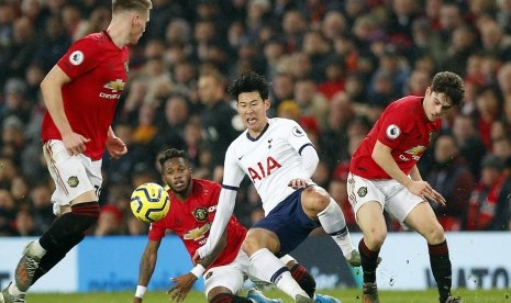 Penyerang Tottenham Hotspur Son Heung-min berjibaku menguasai bola melawan tiga pemain Manchester United (MU). MU mengalahkan Tottenham 2-1.