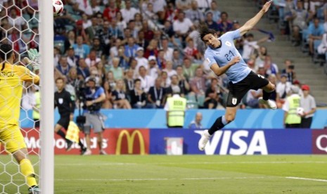 Penyerang Uruguay, Edinson Cavani, saat menjebol gawang Portugal.