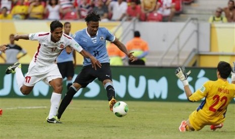 Penyerang Uruguay (kostum biru) mencetak gol ke gawang Tahiti di Piala Konfederasi 2013.